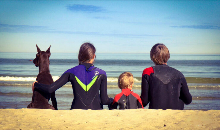 Surfarite pere rannas oma suure koeraga.