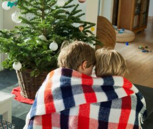kaks last teki sees jõulupuu all istumas