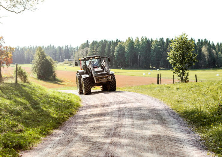 Traktor sõidab farmis ringi.