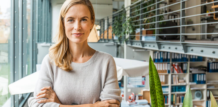 Naine seisab kindla näoga kontoris