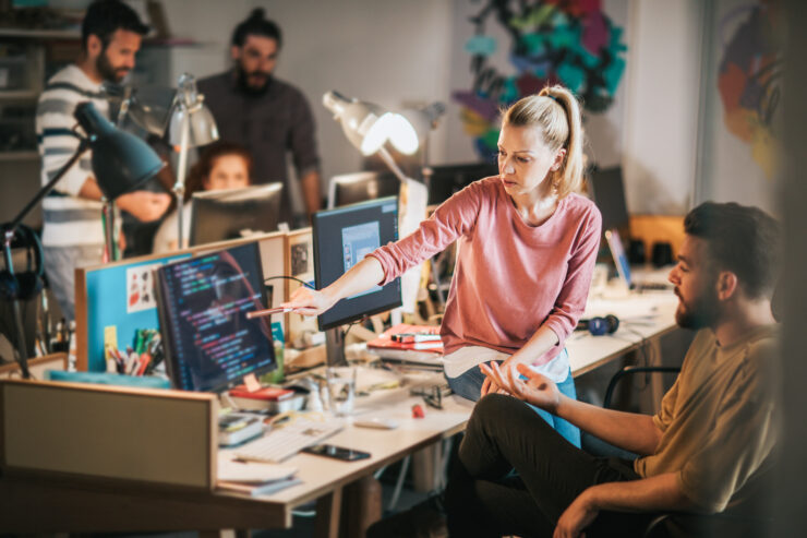 Grupp IT inimesi kontoris arutamas töö teemade üle.