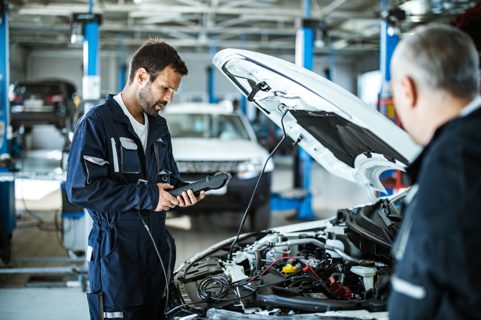 Mehed auto töökojas autosid parandamas