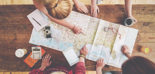 Kolm inimest kaarti vaatamas ja reisi planeerimas