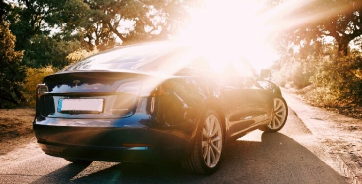 Elektriauto päikeseloojangu taustal.