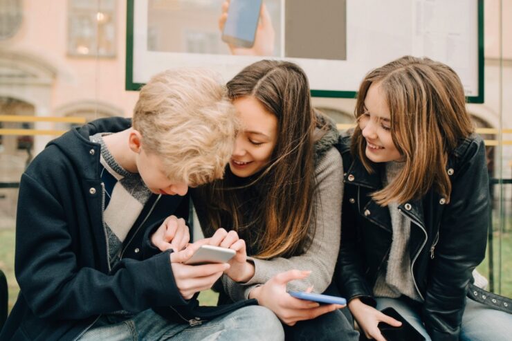 Lapsed vaatavad telefonist kõik koos midagi.