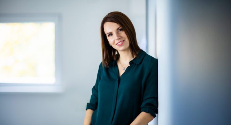 Jätkusuutlik investeerimine, naine naeratab ja vaatab kaamerasse.