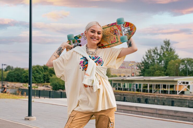 Swedbank rahakoguja. Pildil on noor naine rula ja streetwear riietega