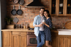 Mees ja naine seisavad köögis lähestikku ja vaatavad kaamerasse.