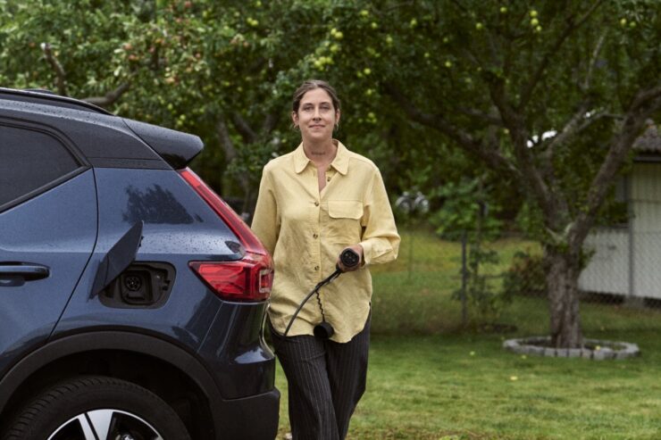 elektriauto: naine hakkab laadima oma elektriautot.