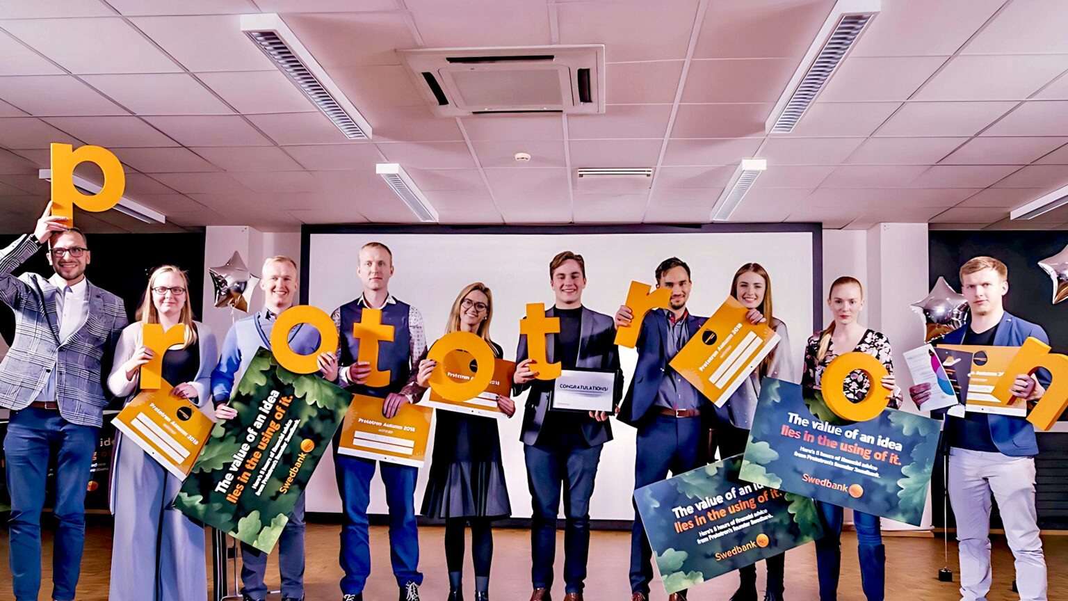 Pildil on Prototroni võitjad koos diplomitega ja võtmeisikud. Nad hoiavad käes silti Prototron.