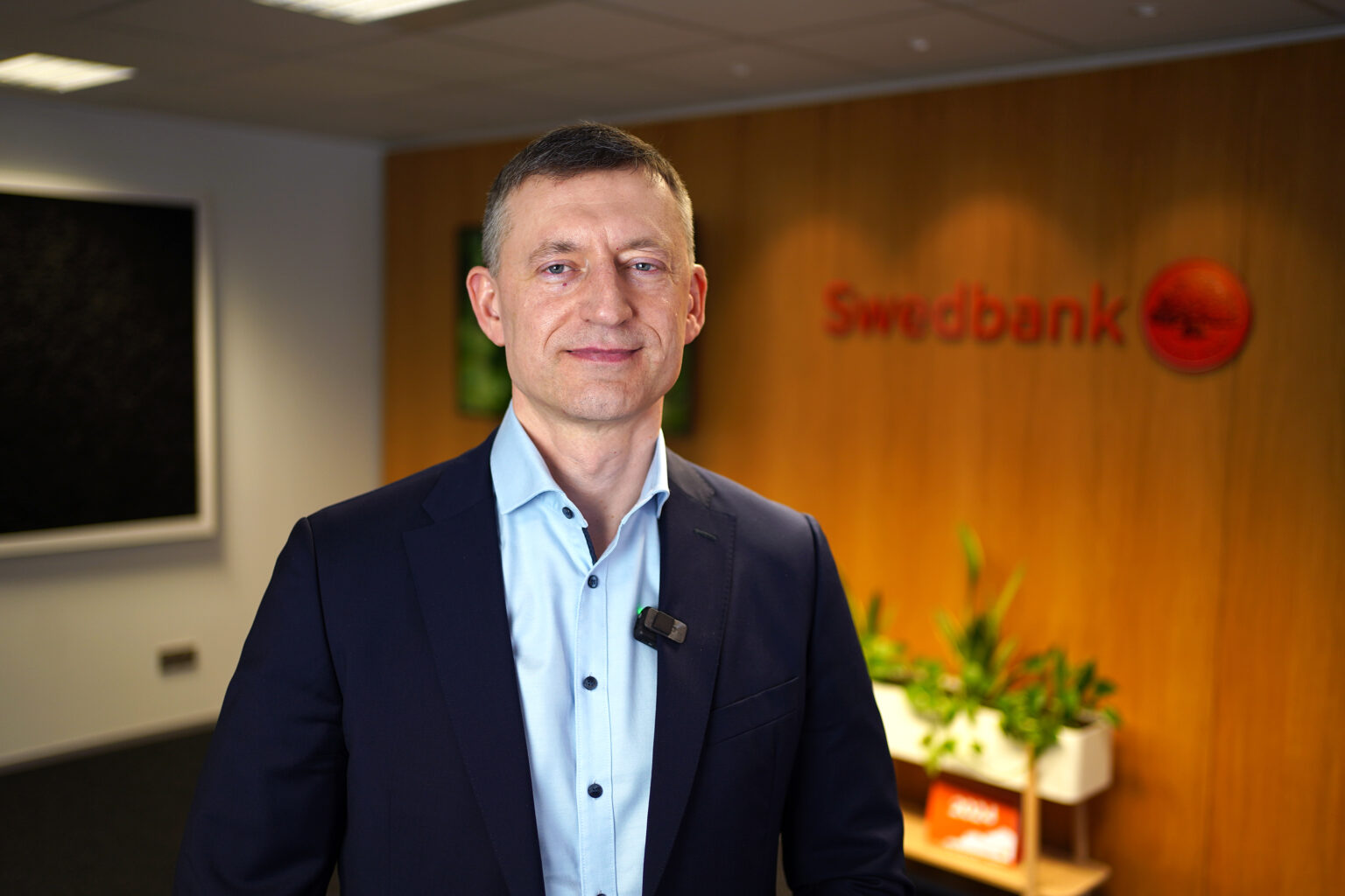 Raul Kirsimäe seisab Swedbanki logo ees.