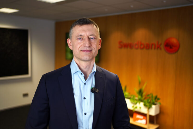 Raul Kirsimäe seisab Swedbanki logo ees.