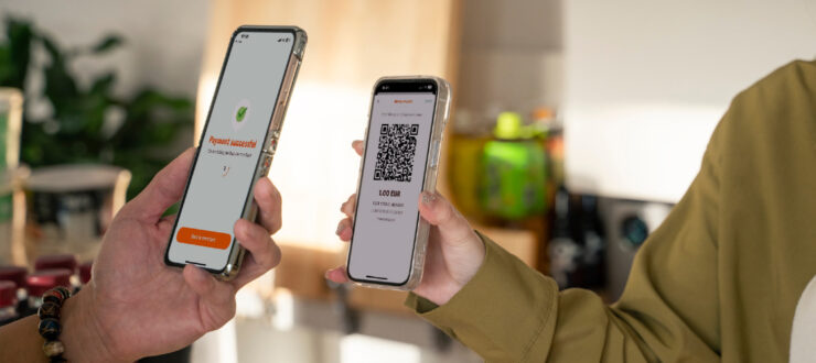 Pildil on kaks telefoni, üks maksab teisele skännides QR koodi.