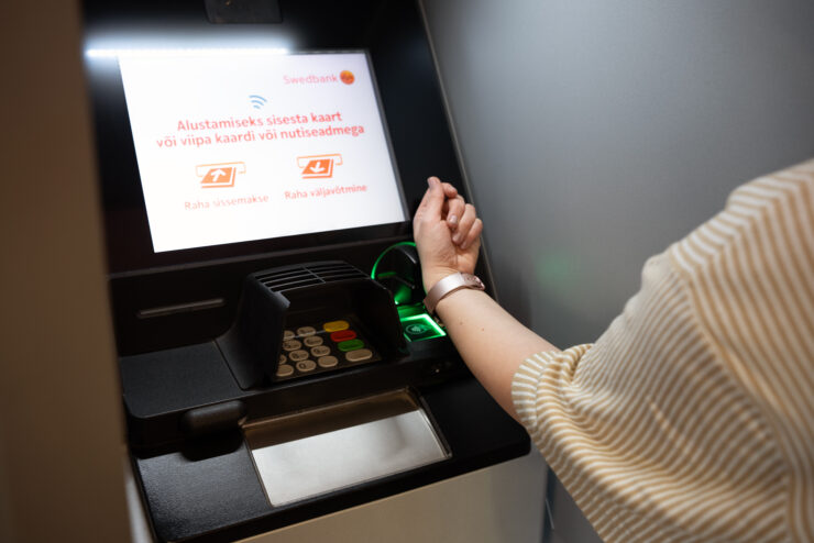 Pildil on ATM-i masin, kus viibatakse nutikellaga.