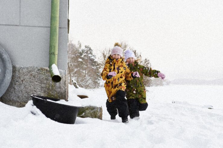 Kaks väikest last lumes möllamas.
